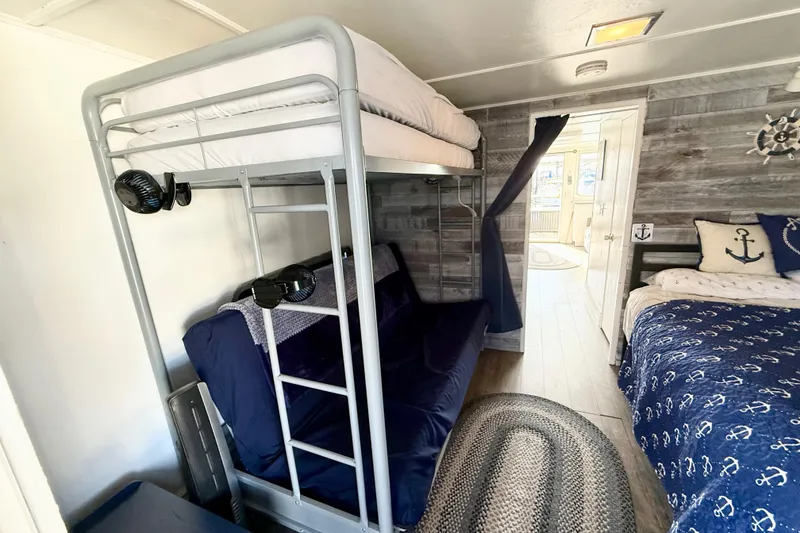 Slide: The Image of Nautical-themed bedroom with bunk bed, anchor decor, and cozy bedding in a 1986 Hilburn 4014 Executive. - 16