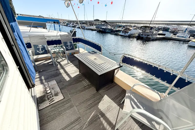 Slide: The Image of Deck of 1986 Hilburn 4014 Executive houseboat with seating, table, and marina view. - 17