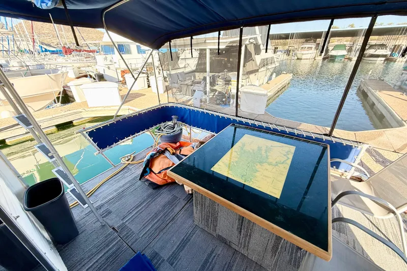 Slide: The Image of 1986 Hilburn 4014 Executive boat interior with map table, docked at marina. - 19