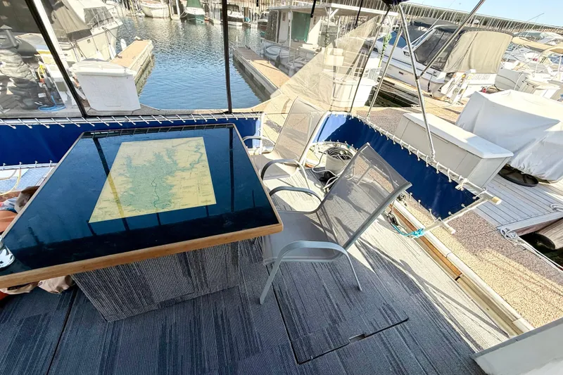 Slide: The Image of Outdoor seating area on a 1986 Hilburn 4014 Executive boat with a map on the table. - 20