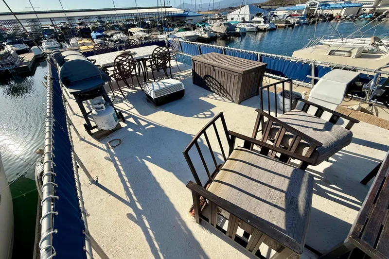 Slide: The Image of Rooftop deck of 1986 Hilburn 4014 Executive houseboat with seating and grill at marina. - 22