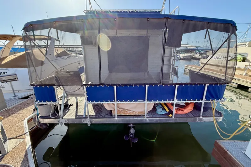 Slide: The Image of 1986 Hilburn 4014 Executive houseboat docked with blue canopy and screened enclosure. - 26