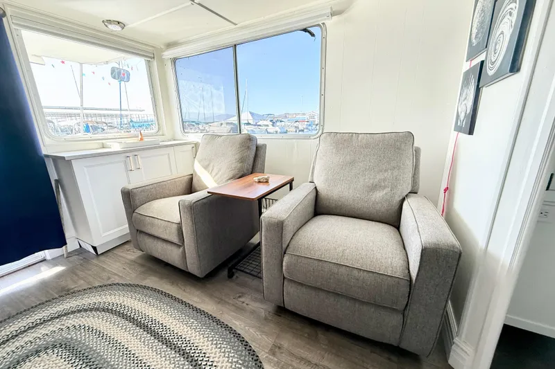 Slide: The Image of Cozy interior of 1986 Hilburn 4014 Executive with two gray armchairs and marina view. - 7