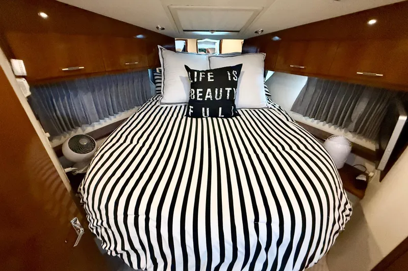 Slide: The Image of Luxurious bedroom in 2007 Carver 36 Sedan with striped bedding and decorative pillows. - 28