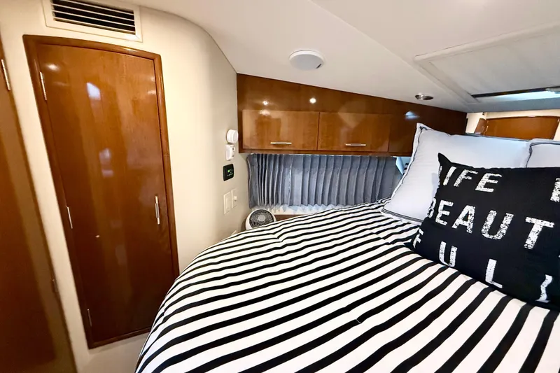 Slide: The Image of Interior of 2007 Carver 36 Sedan with striped bedding and wooden cabinetry. - 30