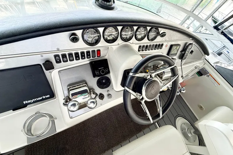 Slide: The Image of Helm of 2007 Carver 36 Sedan with steering wheel, gauges, and Raymarine navigation system. - 39