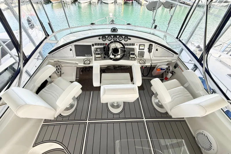 Slide: The Image of 2007 Carver 36 Sedan helm with four white captain chairs and modern controls. - 49