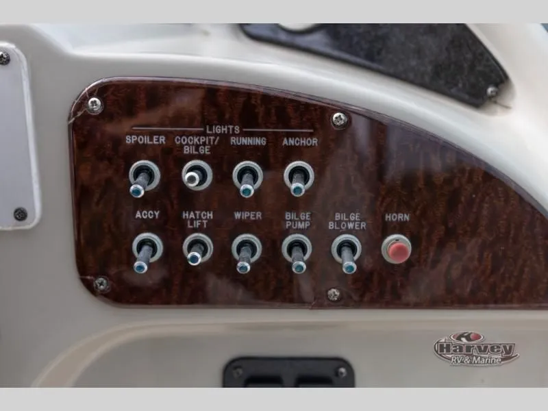 Slide: The Image of Control panel of a 2005 SUNDANCER 260 boat with various switches. - 14