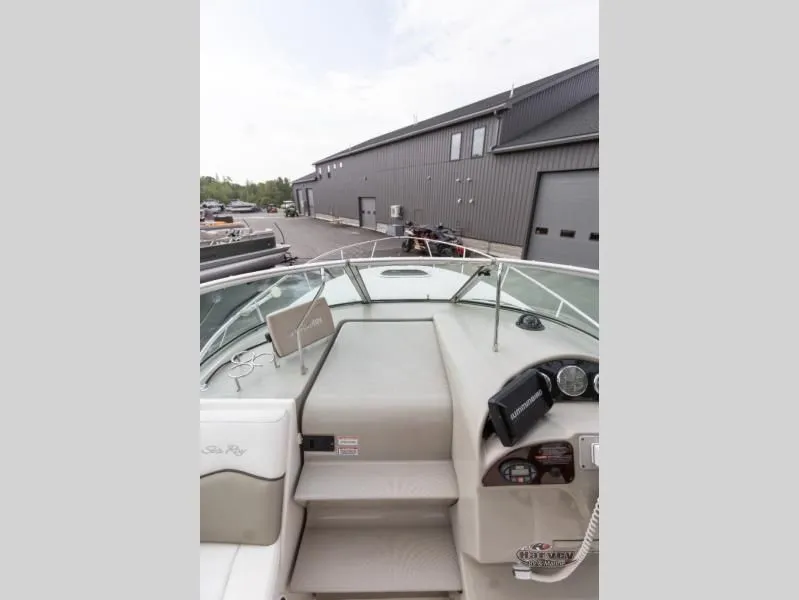 Slide: The Image of 2005 SUNDANCER 260 boat deck with helm, shipyard in background. - 18