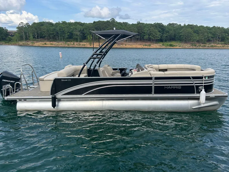 The Image of 2020 Harris Sunliner 250 pontoon boat on a calm lake. - 1