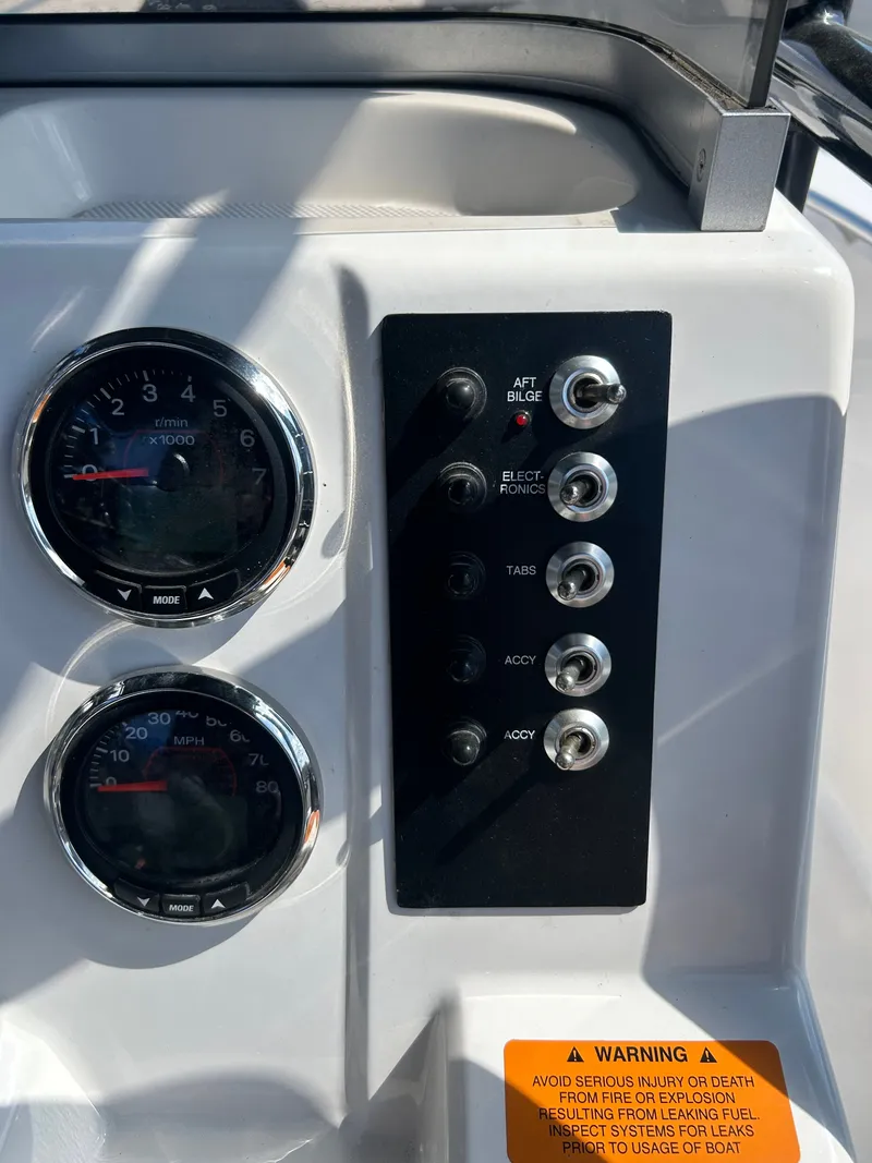 Slide: The Image of Dashboard of a 2018 Robalo R180CC boat with switches and gauges. - 14