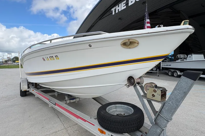 Slide: The Image of 2002 Formula 292 FASTech boat on trailer, parked outside a building under a cloudy sky. - 10