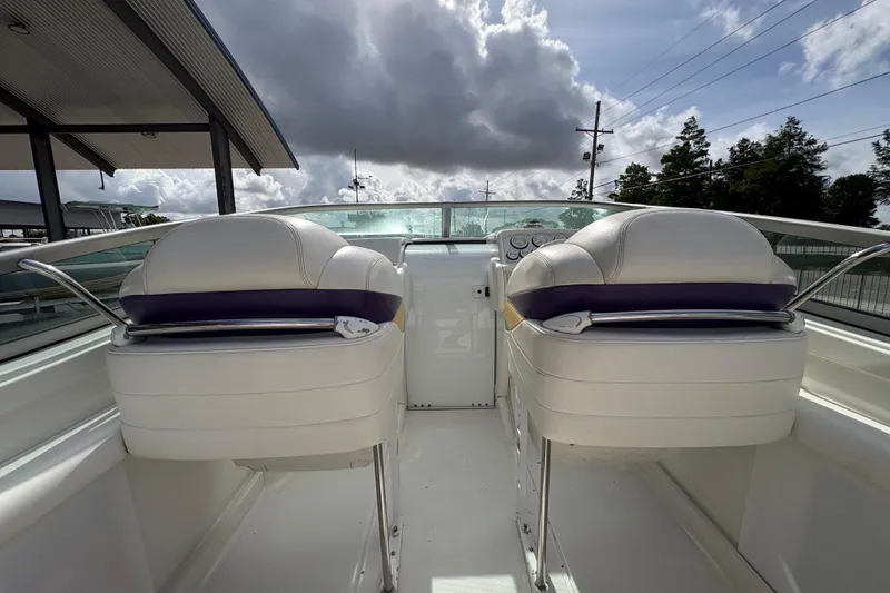 Slide: The Image of 2002 Formula 292 FASTech boat interior with white seats and dashboard under cloudy sky. - 18
