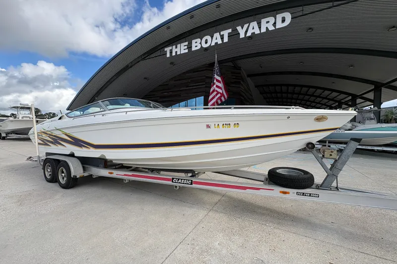 Slide: The Image of 2002 Formula 292 FASTech boat on trailer at The Boat Yard, American flag displayed. - 2
