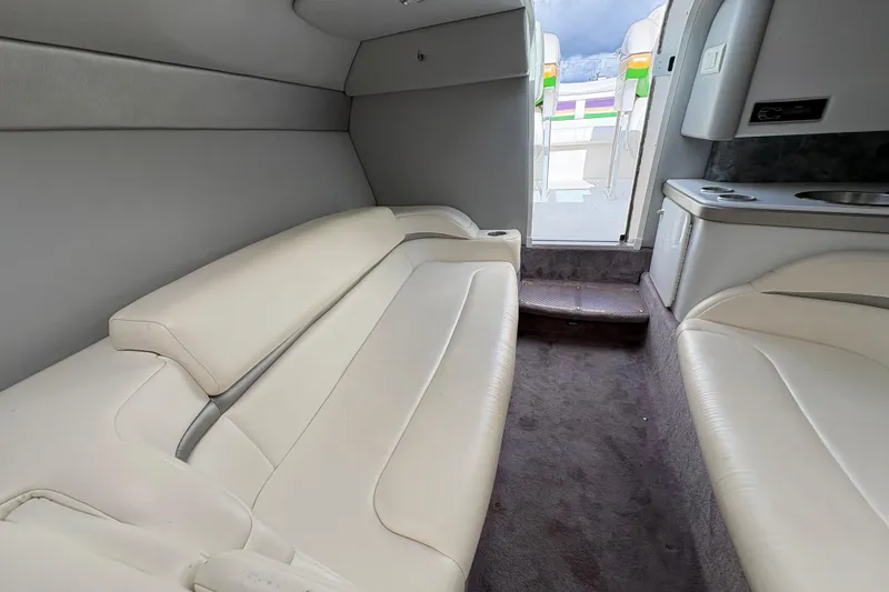 Slide: The Image of Interior of a 2002 Formula 292 FASTech boat with white leather seating and compact kitchenette. - 25