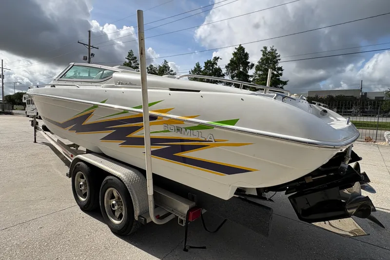 Slide: The Image of 2002 Formula 292 FASTech boat on trailer, featuring vibrant graphics, parked outdoors. - 6