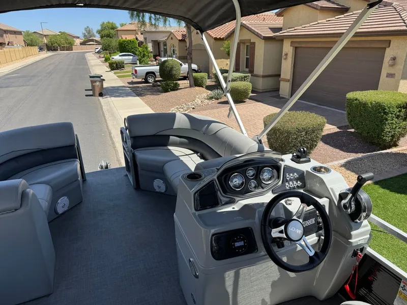 Slide: The Image of Lowe pontoon boat 2021 parked on residential street, interior view of helm. - 2