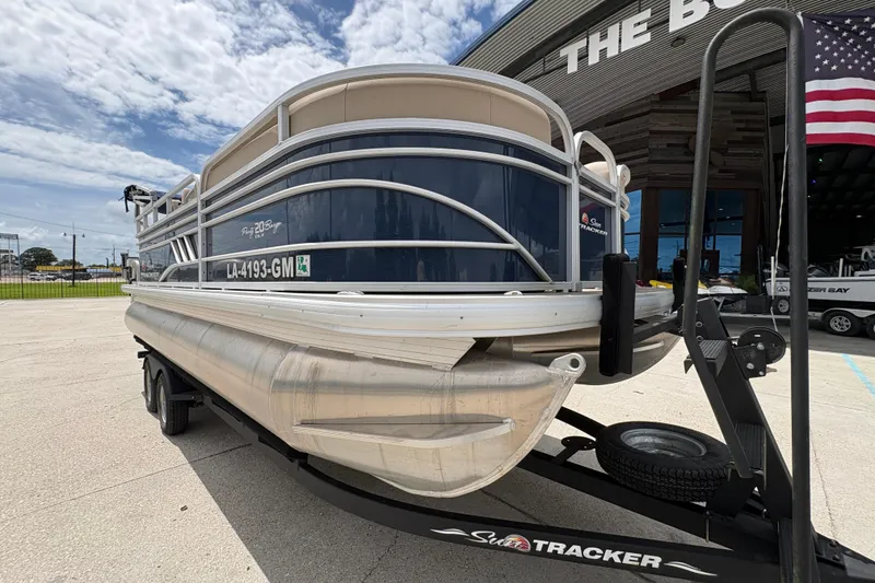 Slide: The Image of 2021 Sun Tracker Party Barge 20 DLX pontoon boat on trailer, parked outdoors. - 10