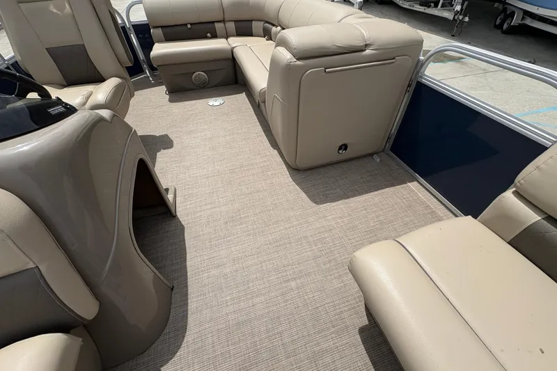 Slide: The Image of 2021 Sun Tracker Party Barge 20 DLX interior with beige seating and carpeted floor. - 14