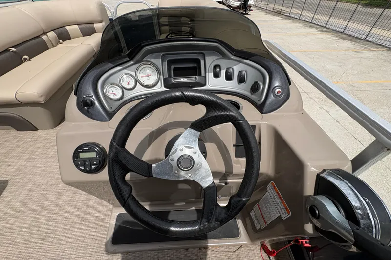 Slide: The Image of 2021 Sun Tracker Party Barge 20 DLX steering console with gauges and controls. - 17
