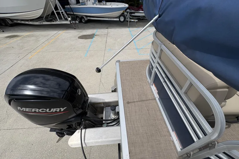 Slide: The Image of 2021 Sun Tracker Party Barge 20 DLX with Mercury outboard motor, docked on concrete. - 20