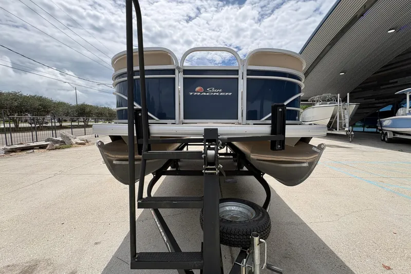 Slide: The Image of 2021 Sun Tracker Party Barge 20 DLX pontoon boat on trailer, outdoor setting. - 9