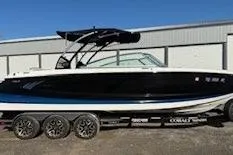 The Image of 2018 Cobalt A28 boat on trailer, black and white design, parked outdoors. - 1