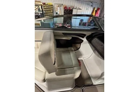 Slide: The Image of 2018 Cobalt A28 boat interior with beige seating and dashboard in a garage setting. - 17