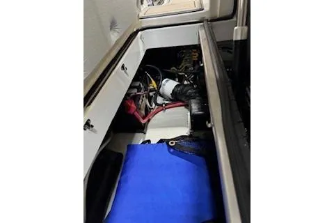 Slide: The Image of 2018 Cobalt A28 boat storage compartment with wiring and blue cover. - 25