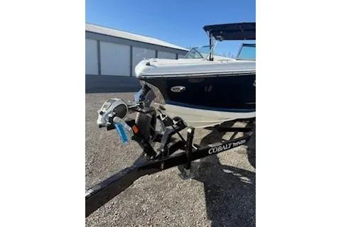 Slide: The Image of 2018 Cobalt A28 boat on trailer, parked outdoors near a building. - 9