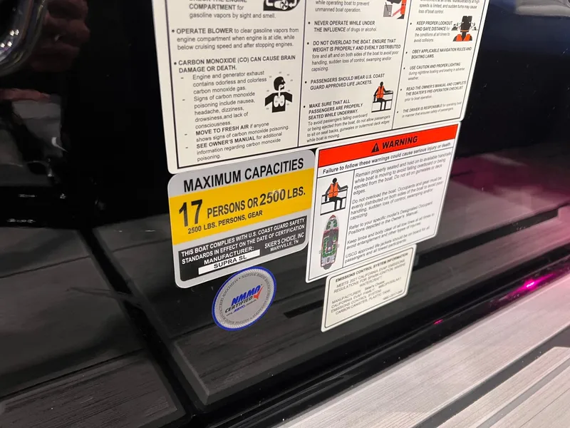 Slide: The Image of Warning labels and capacity sticker on a 2021 Supra SL 400 boat. - 27