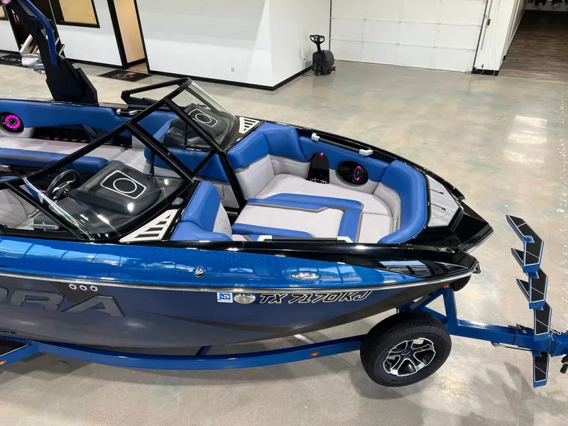 Slide: The Image of 2021 Supra SL 400 boat with blue and gray interior in a garage. - 9
