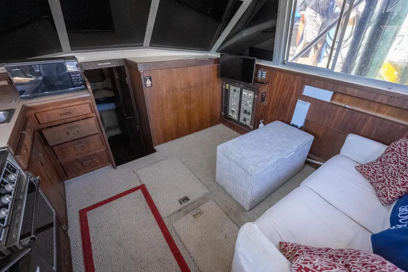 Slide: The Image of Interior of a 1986 Bertram 35 Flybridge Sportfish with cozy seating and wooden cabinetry. - 17