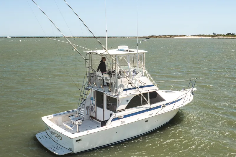 Slide: The Image of 1986 Bertram 35 Flybridge Sportfish boat cruising on open water. - 3
