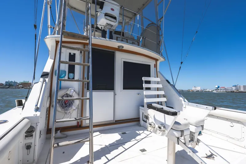 Slide: The Image of 1986 Bertram 35 Flybridge Sportfish boat with ladder and fishing chair on deck. - 8