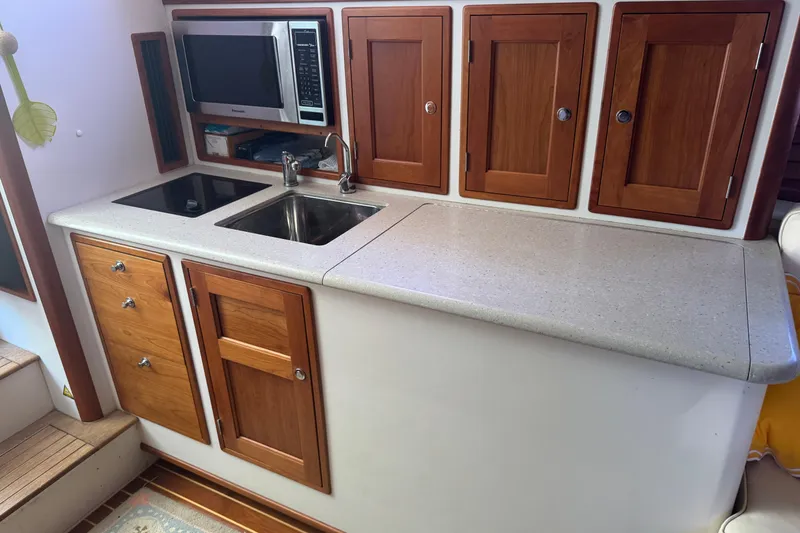 Slide: The Image of Compact galley kitchen in 2006 MJM 34z Downeast boat with wooden cabinets and modern appliances. - 14