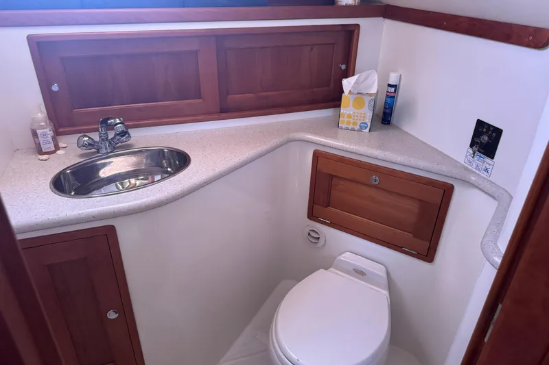 Slide: The Image of 2006 MJM 34z Downeast boat bathroom with sink, toilet, and wooden cabinetry. - 15