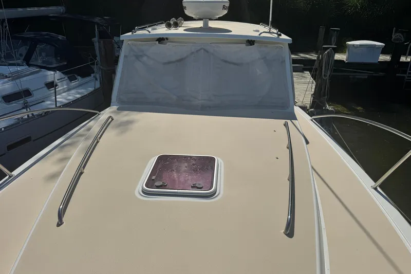 Slide: The Image of 2006 MJM 34z Downeast boat deck with hatch and railing, docked beside other boats. - 4
