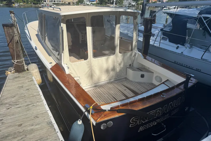 Slide: The Image of 2006 MJM 34z Downeast boat docked, featuring a covered cockpit and wooden accents. - 5