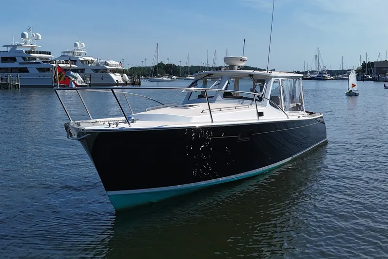 Slide: The Image of A 2006 MJM 34z Downeast boat is on the water, surrounded by other yachts in the harbor. - 17