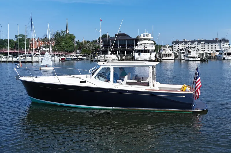 The Image of A 2006 MJM 34z Downeast boat on the water, surrounded by yachts and buildings. - 0