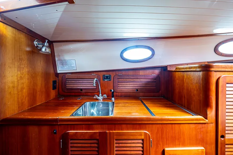 Slide: The Image of Interior of 1996 Hinckley Picnic Boat 36 Classic with wooden cabinetry and stainless steel sink. - 12