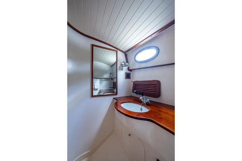 Slide: The Image of Hinckley Picnic Boat 36 Classic 1996 bathroom with wooden countertop and oval window. - 16
