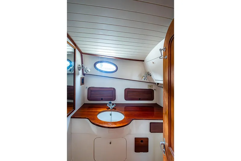 Slide: The Image of Hinckley Picnic Boat 36 Classic 1996 bathroom with wooden countertop and oval window. - 17