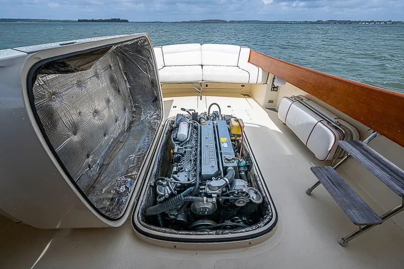 Slide: The Image of Hinckley Picnic Boat 36 Classic 1996 engine compartment with open hatch, docked on calm water. - 18
