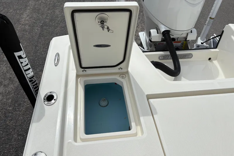Slide: The Image of 2025 Pathfinder 2200 TRS boat with open storage compartment and visible engine components. - 12