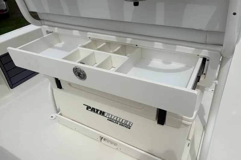 Slide: The Image of 2025 Pathfinder 2200 TRS boat storage compartment with organized tackle drawer. - 18