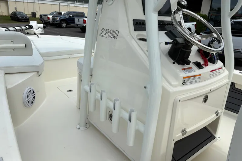 Slide: The Image of 2025 Pathfinder 2200 TRS boat interior with steering console and rod holders. - 26
