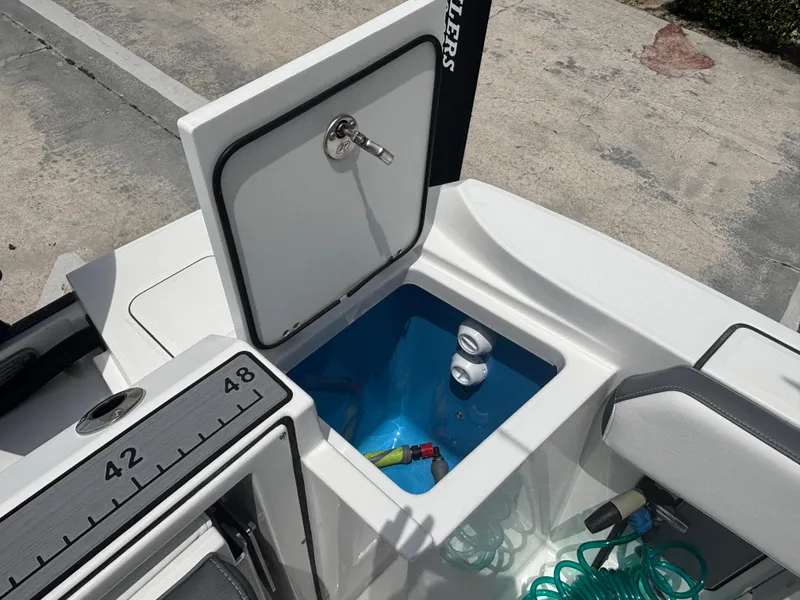 Slide: The Image of Open storage compartment on 2019 Blackfin 242 CC boat with measuring scale. - 15