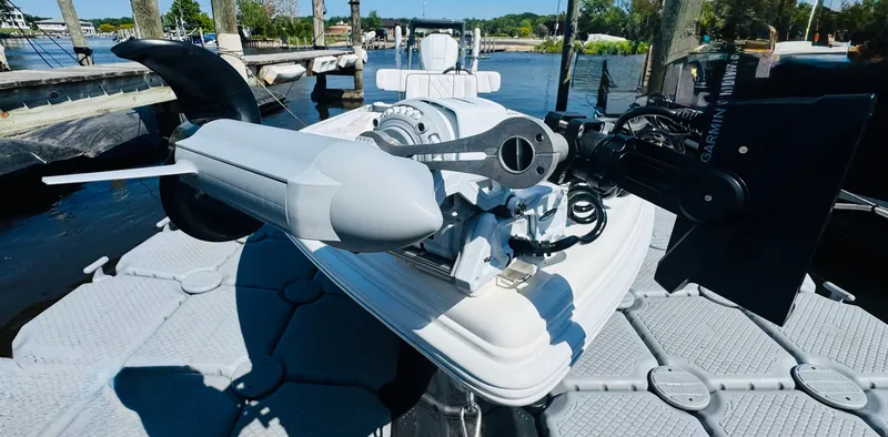 Slide: The Image of Vtech 18' Flats boat motor, 2027 model, on a dock by the water. - 29